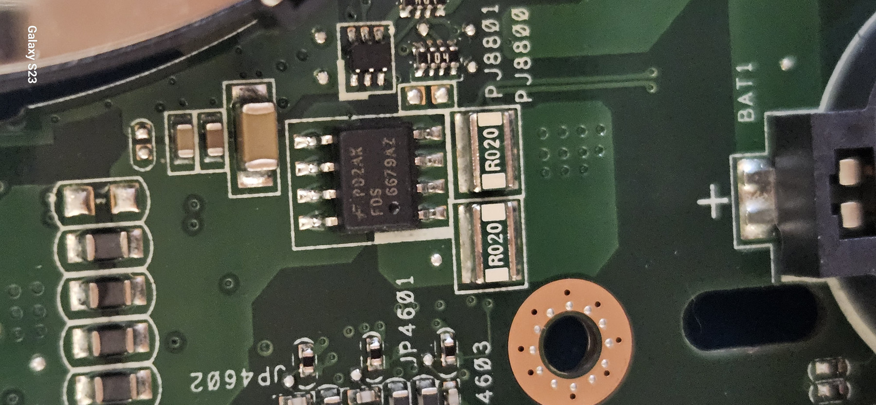 Extreme close-up of component-level board repair work